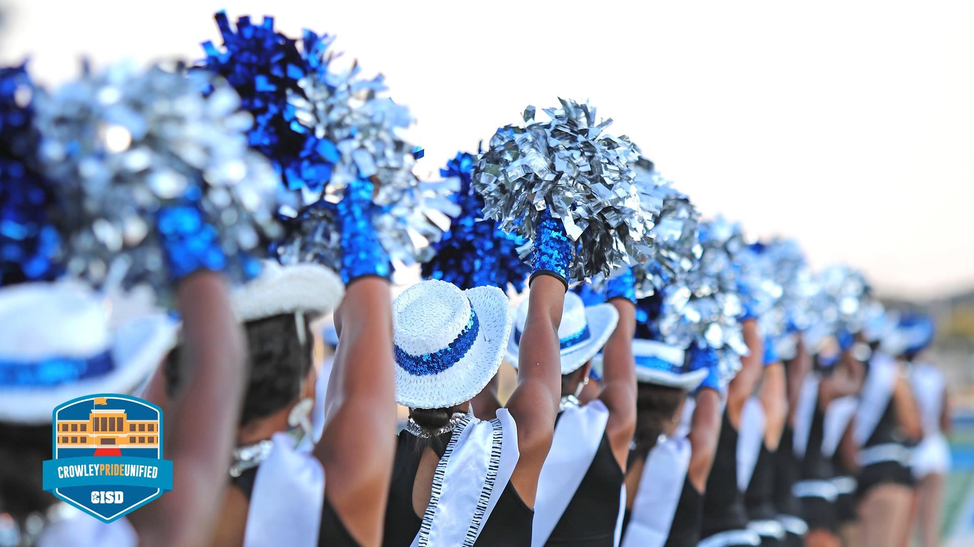 Cheerleaders holding poms in the air 