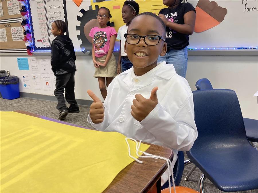 Student smiling and giving thumbs up